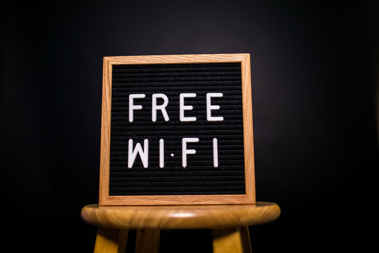 Στη φωτογραφία παρουσιάζεται ένας πίνακας με τις λέξεις "Δωρεάν Wi-Fi", δηλώνοντας πιθανότατα ότι στη συγκεκριμένη τοποθεσία παρέχεται δωρεάν πρόσβαση στο διαδίκτυο μέσω Wi-Fi